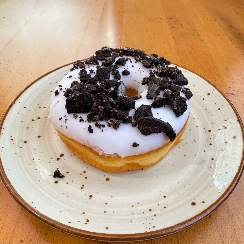 Cookies & Cream donut — white vanilla glaze with dark cookie crumble