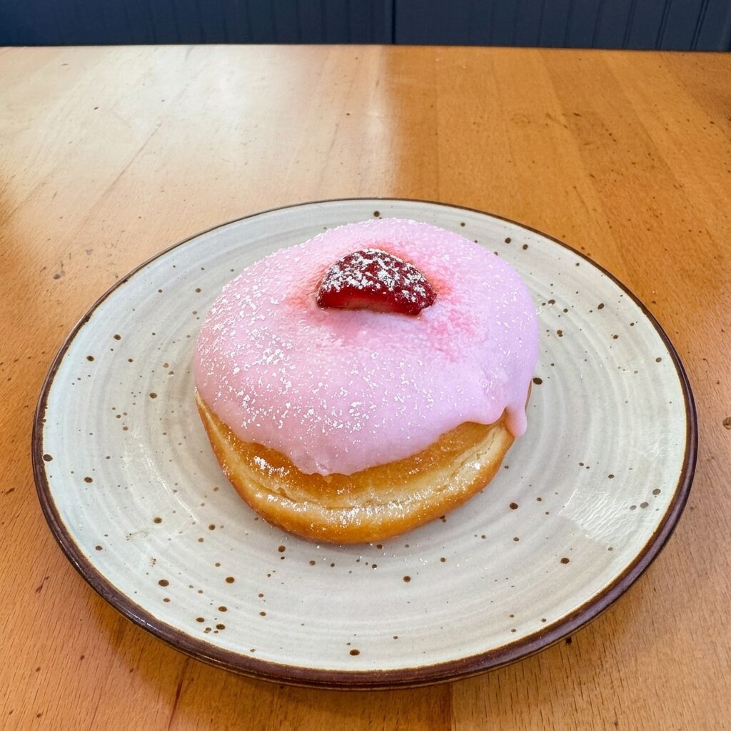Pink strawberry donut topped with a strawberry slice